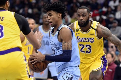 Memphis Grizzlies guard Ja Morant (12) handles the ball between Los Angeles Lakers forwards LeBron James (23) and Anthony Davis (3) in the first half of an NBA basketball game Saturday, Feb. 29, 2020, in Memphis, Tenn. (AP Photo/Brandon Dill)