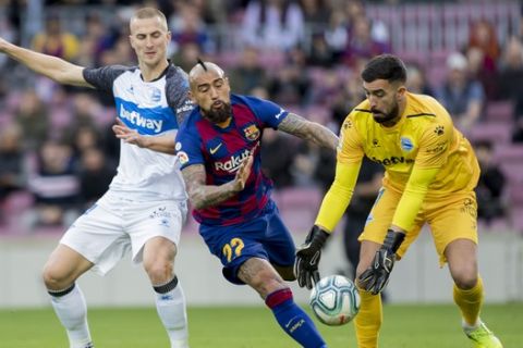 Barcelona's Arturo Vidal, center, fights for the ball during a Spanish La Liga soccer match between Barcelona and Alaves at Camp Nou stadium in Barcelona, Spain, Saturday, Dec. 21, 2019. (AP Photo/Joan Monfort)