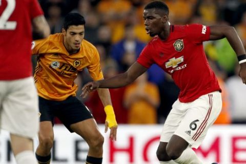 Manchester United's Paul Pogba, right, duels for the ball with Wolverhampton Wanderers' Raul Jimenez, center, during the English Premier League soccer match between Wolverhampton Wanderers and Manchester United at the Molineux Stadium in Wolverhampton, England, Monday, Aug. 19, 2019. (AP Photo/Rui Vieira)