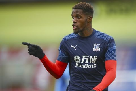Crystal Palace's Wilfried Zaha gestures during the warm up ahead of the English Premier League soccer match between Crystal Palace and Burnley at Selhurst Park, in London, England, Monday, June 29, 2020. (AP Photo/Hannah McKay,Pool)