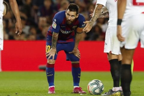 Barcelona's Lionel Messi, center, stands by the ball before shooting and scoring a free kick during Spanish La Liga soccer match between Barcelona and Sevilla at the Camp Nou stadium in Barcelona, Sunday, Oct. 6, 2019. Messi scored once in Barcelona's 4-0 victory. (AP Photo/Joan Monfort)