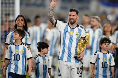 Argentina's Lionel Messi walks with the winning team replica of the FIFA World Cup trophy, accompanied by his Antonela Roccuzzo and children, during a celebration ceremony for local fans after an international friendly soccer match against Panama at the Monumental stadium in Buenos Aires, Argentina, Thursday, March 23, 2023. (AP Photo/Natacha Pisarenko)