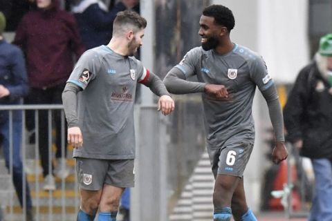 Curzon Ashton's Robert Evans, left, bumps elbows with teammate Mohamud Ali after the final whistle during the Vanarama National League North match at Horsfall Stadium, Bradford, England, Saturday, March 14, 2020. For most people, the new coronavirus causes only mild or moderate symptoms. For some it can cause more severe illness, especially in older adults and people with existing health problems. (Dave Howarth/PA via AP)