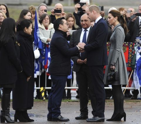 Aiyawatt Srivaddhanaprabha, the son of Vichai Srivaddhanaprabha, meets Britain's Prince William and Kate, Duchess and Duke of Cambridge, right, during a visit to pay their tribute to those who were tragically killed in a helicopter crash, at Leicester City Football Club's King Power Stadium in Leicester, England, Wednesday, Nov. 28, 2018. Vichai Srivaddhanaprabha, the Thai billionaire owner of Premier League team Leicester City was among five people who died after his helicopter crashed and burst into flames shortly after taking off from the soccer field on Saturday Oct. 27, 2018. (AP Photo/Rui Vieira)