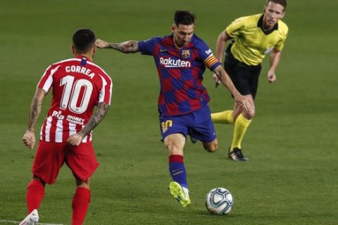 Barcelona's Lionel Messi, center, kicks the ball in front Atletico Madrid's Angel Correa during the Spanish La Liga soccer match between FC Barcelona and Atletico Madrid at the Camp Nou stadium in Barcelona, Spain, Tuesday, June 30, 2020. (AP Photo/Joan Monfort)