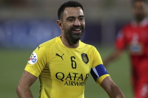 Qatar's Al-Sadd player Xavi Hernández, a former Barcelona and Spain's midfielder, smiles as the match is paused during his final match with Iran's Persepolis in AFC Champions League at the Azadi stadium in Tehran, Iran, Monday, May 20, 2019. Xavi Hernández retired from soccer as a player. He quit international football in 2014 and left Barcelona one year later after 17 seasons. He has since played for Al-Sadd in Qatar while preparing for a future as a manager. (AP Photo/Vahid Salemi)