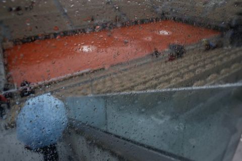 Rain drops trickle down a glass wall on center court where rain delayed the start of quarterfinal matches of the French Open tennis tournament at the Roland Garros stadium in Paris, Wednesday, June 5, 2019. (AP Photo/Christophe Ena)