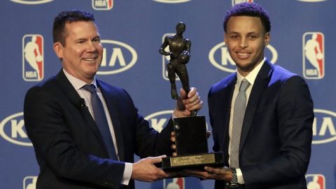 Golden State Warriors guard Stephen Curry, right, is presented with the NBA's Most Valuable Player award by Tim Chaney, of Kia Motors, at a basketball news conference announcing Curry as the NBA Most Valuable Player in Oakland, Calif., Monday, May 4, 2015. Curry won the league's top individual award Monday, beating out Houston's James Harden in a race that turned out not to be that close. (AP Photo/Jeff Chiu)