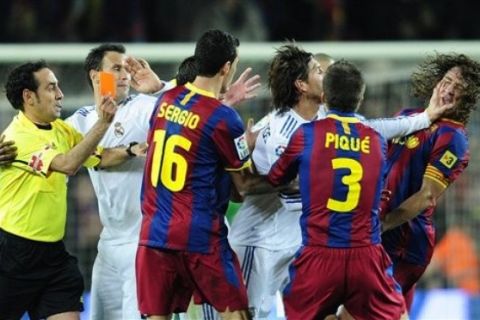 Real Madrid's Sergio Ramos, third right, clashes with FC Barcelona's Carles Pujol, right, during a Spanish La Liga soccer match at the Camp Nou stadium in Barcelona, Spain, Monday, Nov. 29, 2010. (AP Photo/Manu Fernandez)
