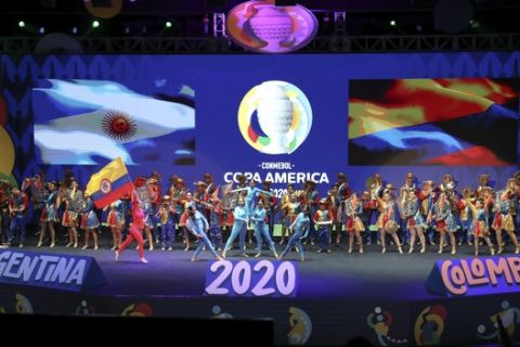 Performers dance during the draw for the 2020 Copa America soccer tournament in Cartagena, Colombia, Tuesday, Dec. 3, 2019. The continental championship will be held in Colombia and Argentina from June 12 to July 12 next year. (AP Photo/Fernando Vergara)