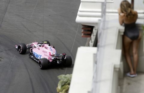 A woman watches Force India driver Esteban Ocon of France steering his car during a practice session in Monaco, Thursday, May 24, 2018. The Formula one race will be held on Sunday. (AP Photo/Luca Bruno)