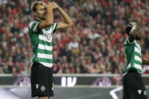 Sporting's Bas Dost, left, reacts after missing a chance to score during a Portuguese league soccer match between Benfica and Sporting at the Luz stadium in Lisbon, Sunday, Dec. 11, 2016. Benfica won 2-1. (AP Photo/Armando Franca)
