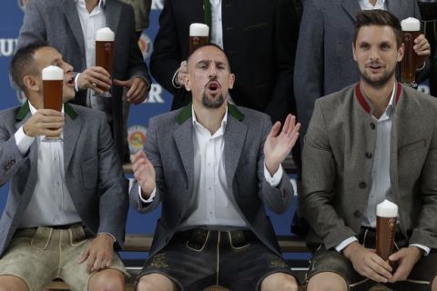Bayern's Rafinha, left, Franck Ribery and Sven Ulreich sing a birthday song for team mate Thomas Mueller in traditional Bavarian clothes during a photo-shooting of a beer brewing company in Munich, Germany, Wednesday, Sept. 13, 2017. Mueller celebrates his 28th birthday today. (AP Photo/Matthias Schrader)