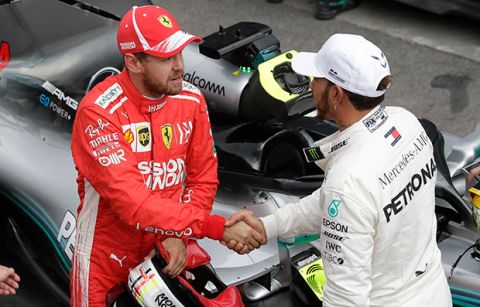 Mercedes driver Lewis Hamilton, of Britain, right, who clocked the the fastest time, shakes hands with Ferrari driver Sebastian Vettel, of Germany, second fastest, after the qualifying session for the Brazilian Formula One Grand Prix at the Interlagos race track in Sao Paulo, Brazil, Saturday, Nov. 10, 2018. (AP Photo/Andre Penner)