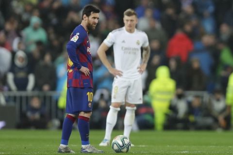 Barcelona's Lionel Messi, left, reacts after Real Madrid's Mariano Diaz scored his side's second goal during the Spanish La Liga soccer match between Real Madrid and Barcelona at the Santiago Bernabeu stadium in Madrid, Spain, Sunday, March 1, 2020. (AP Photo/Manu Fernandez)