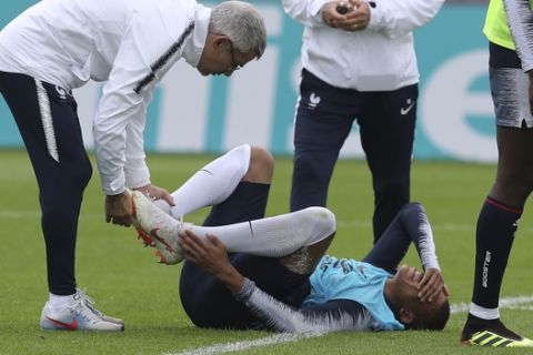 France's Kylian Mbappe grimaces after being injured during a training session at the 2018 soccer World Cup in Glebovets, Russia, Tuesday, June 12, 2018. (AP Photo/David Vincent)