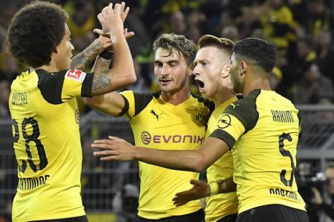 Dortmund's scorer Marco Reus, 2nd from right, celebrates with Dortmund's Axel Witsel, left, after he scored his side's second goal during the German Bundesliga soccer match between Borussia Dortmund and 1.FC Nuremberg in Dortmund, Germany, Wednesday, Sept. 26, 2018. (AP Photo/Martin Meissner)