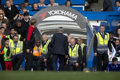 Chelsea's head coach Jose Mourinho, center in suit, walks down the tunnel after shaking hands with Liverpool's head coach Juergen Klopp, flanking him at left, after the final whistle of the English Premier League soccer match between Chelsea and Liverpool at Stamford Bridge stadium in London, Saturday, Oct. 31, 2015.  (AP Photo/Matt Dunham)