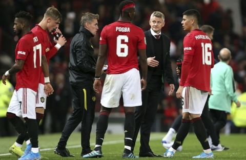 Manchester United's Paul Pogba and manager Ole Gunnar Solskjaer in discussion before penalty kicks during the Carabao Cup, Third Round match at Old Trafford, Manchester, Wednesday September 25, 2019. (Richard Sellers/PA via AP)