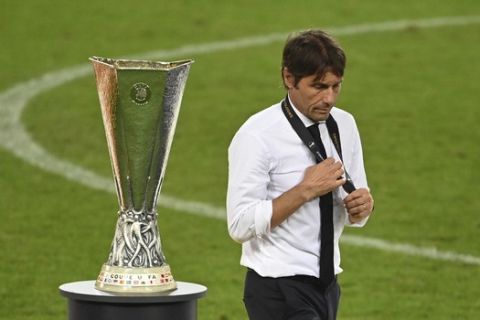 Inter Milan's head coach Antonio Conte walks past the trophy after the Europa League final soccer match between Sevilla and Inter Milan in Cologne, Germany, Friday, Aug. 21, 2020. (Ina Fassbender/Pool via AP)