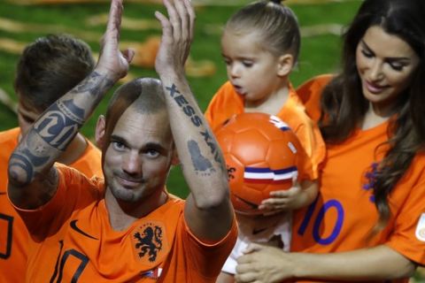 Wesley Sneijder of The Netherlands greets fans as he walks off the pitch with his wife Yolanthe, right, and his children Xess Xava, second right, en Jessey, left, as he retires from international soccer after the international friendly soccer match between The Netherlands and Peru at the Johan Cruijff ArenA in Amsterdam, Netherlands, Thursday, Sept. 6, 2018. The friendly against Peru is the 134th and last for 34-year-old Sneijder, a Dutch record. His first international was a 1-1 draw with Portugal on April 30, 2003. The attacking midfielder has played for clubs including Ajax, Real Madrid and Inter Milan. (AP Photo/Peter Dejong)