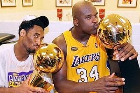 STA21D:SPORT-NBA:LOS ANGELES,CA,19JUN00 - Los Angeles Lakers center Shaquille O'Neal (R) kisses the Most Valuable Player trophy as teammate Kobe Bryant kisses the NBA Finals trophy as they celebrate in the locker room after winning the NBA Finals against the Indiana Pacers, June 19. The Lakers beat the Pacers, 4 games to 2 to win the series, after winning tonight's Game 6, 116 - 111. rtw/Photo by Mike Blake REUTERS