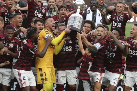 Players of Brazil's Flamengo celebrate after they defeated Argentina's River Plate 2-1 to win the the Copa Libertadores final soccer match at the Monumental stadium in Lima, Peru, Saturday, Nov. 23, 2019. (AP Photo/Martin Mejia)