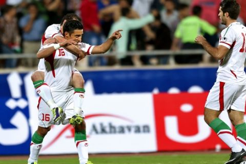 Reza Ghoochannejad and Mohammad Reza Khalatbari (left) and Karim Ansarifard (right) celebrate after Iran scored during a soccer match in AFC Asian Cup qualifiers at the Azadi (Freedom) stadium, in Tehran, Iran, Tuesday, Oct 15, 2013. (AP Photo/Ebrahim Noroozi)