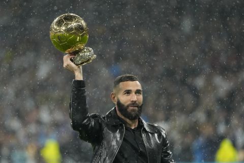 Real Madrid's Karim Benzema holds the 2022 Ballon d'Or trophy prior to the Spanish La Liga soccer match between Real Madrid and Sevilla at the Santiago Bernabeu stadium in Madrid, Saturday, Oct. 22, 2022. (AP Photo/Manu Fernandez)