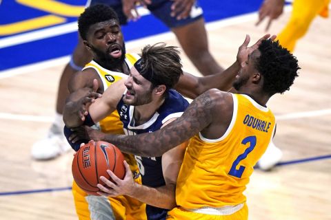 Monmouth guard George Papas, center, is fouled by Pittsburgh guard Onyebuchi Ezeakudo, left, and Pittsburgh guard Femi Odukale (2) during the second half of the team's NCAA college basketball game in Pittsburgh, Sunday, Dec. 12, 2021. Monmouth won 56-52. (AP Photo/Gene J. Puskar)