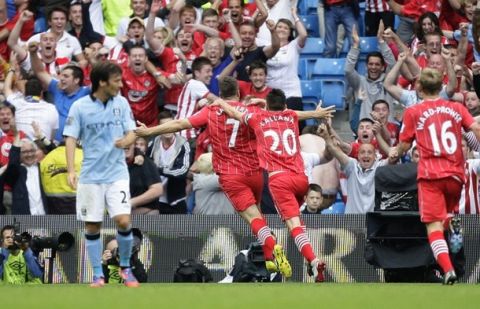 Southampton's Rickie Lambert, centre left, celebrates with teammates after scoring against Manchester City during their English Premier League soccer match at The Etihad Stadium, Manchester, England, Sunday, Aug. 19, 2012. (AP Photo/Jon Super)