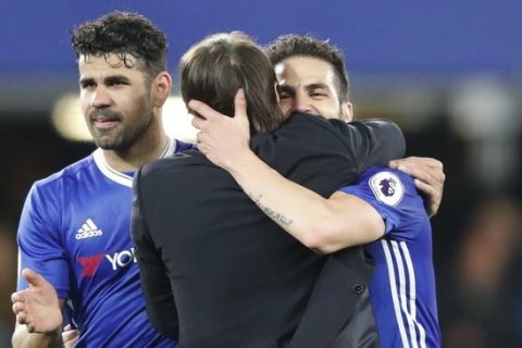 Chelsea's manager Antonio Conte hugs Chelsea's Cesc Fabregas, right, and Chelsea's Diego Costa, left, at the end of the English Premier League soccer match between Chelsea and Middlesbrough at Stamford Bridge stadium in London, Monday, May 8, 2017. Chelsea won the match 3-0. (AP Photo/Frank Augstein)