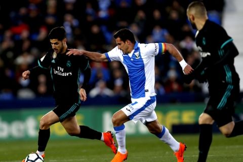 Real Madrid's Marco Asensio, left, vies with Leganes' Gabriel Appelt during a Spanish La Liga soccer match between Real Madrid and Leganes at the Butarque stadium in Leganes, outside Madrid, Wednesday, Feb. 21, 2018. (AP Photo/Francisco Seco)