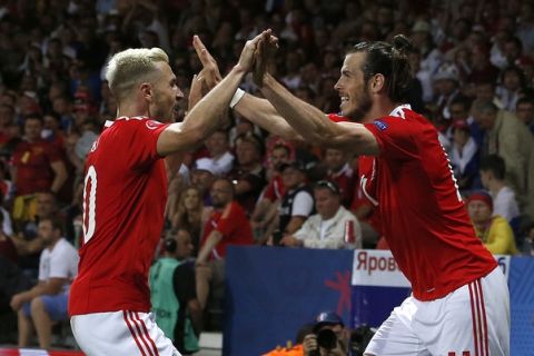 Wales' Gareth Bale, right, and Wales' Aaron Ramsey celebrate after scoring during the Euro 2016 Group B soccer match between Russia and Wales at the Stadium municipal in Toulouse, France, Monday, June 20, 2016. (AP Photo/Hassan Ammar)