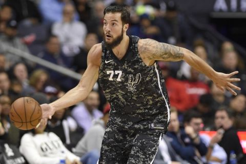 San Antonio Spurs center Joffrey Lauvergne (77) dribbles the ball during the second half of an NBA basketball game against the Washington Wizards, Tuesday, March 27, 2018, in Washington. The Wizards won 116-106. (AP Photo/Nick Wass)