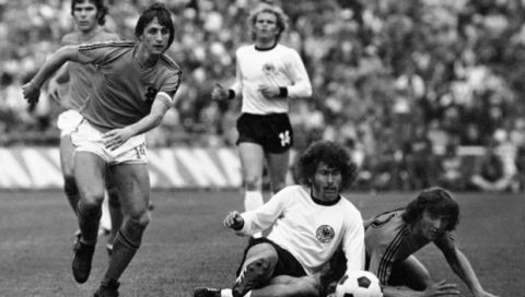 FILE - In this July 7, 1974 file photo, Dutch forward Johan Cruyff, left, runs past German defender Paul Breitner, sitting on the pitch during the World Cup soccer final at the Olympic Stadium in Munich, Germany. Cruyff is regarded as one of the great players not to win the World Cup. Argentina's Lionel Messi and Portugal's  Cristiano Ronaldo are likely to join that list after their teams were eliminated from the 2018 World Cup on Saturday, June 30, 2018. (AP Photo/File)
