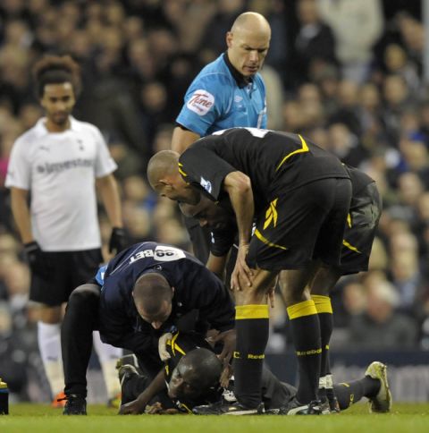 Referee Howard Webb look on as Bolton's English midfielder Fabrice Muamba is treated by medical staff after collapsing during the English FA Cup quarter-final football match between Tottenham Hotspur and Bolton Wanderers at White Hart Lane in north London, England on March 17, 2012. The game was abandoned at half-time as Muamba was taken to hospital. AFP PHOTO/OLLY GREENWOOD

RESTRICTED TO EDITORIAL USE. No use with unauthorized audio, video, data, fixture lists, club/league logos or live services. Online in-match use limited to 45 images, no video emulation. No use in betting, games or single club/league/player publications (Photo credit should read OLLY GREENWOOD/AFP/Getty Images)