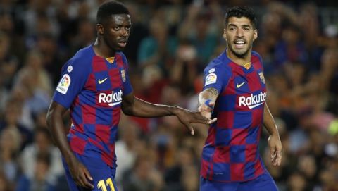 Barcelona's Luis Suarez, right, talks to teammate Ousmane Dembele during Spanish La Liga soccer match between Barcelona and Sevilla at the Camp Nou stadium in Barcelona, Sunday, Oct. 6, 2019. Suarez and Dembele scored once each in Barcelona's 4-0 victory. (AP Photo/Joan Monfort)