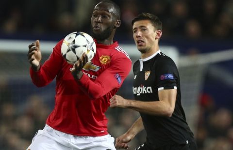 Manchester United's Romelu Lukaku, left shields the ball from Sevilla's Clement Lenglet during the Champions League round of 16 second leg soccer match between Manchester United and Sevilla, at Old Trafford in Manchester, England, Tuesday, March 13, 2018. (AP Photo/Dave Thompson)