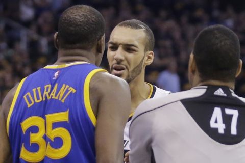 Referee Bennie Adams (47) gets between Golden State Warriors forward Kevin Durant (35) and Utah Jazz center Rudy Gobert, rear, in the second half during Game 3 of the NBA basketball second-round playoff series Saturday, May 6, 2017, in Salt Lake City. Warriors won 102 - 91. (AP Photo/Rick Bowmer)