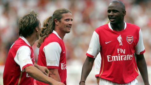 Arsenal Legend's Patrick Vieira, right, talks to Emmanuel Petit, center, and Lee Dixon, left, during their soccer match against Ajax Legend's at the Emirates stadium, London, Saturday July 22,  2006. Saturday's match, the first game to be played in Arsenal's new home stadium, is a tribute match between Arsenal and Ajax to mark the retirement of star striker Dennis Bergkamp.  (AP Photo/Tom Hevezi)