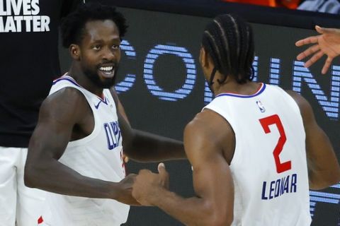 Los Angeles Clippers' Patrick Beverley celebrates with Kawhi Leonard, right, during the team's NBA basketball game against the New Orleans Pelicans on Saturday, Aug. 1, 2020, in Lake Buena Vista, Fla. (Kevin C. Cox/Pool Photo via AP)