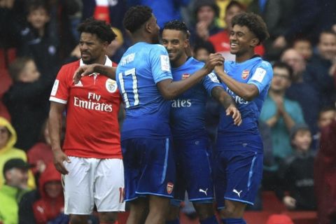 Arsenal's Theo Walcott, centre, celebrates scoring his side's third goal of the game with teammates during the Emirates Cup soccer match against Benfica, at the Emirates Stadium in London, Saturday July 29, 2017. (John Walton/PA via AP)