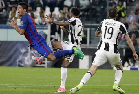 Barcelona's Luis Suarez, left, is airborne after a challenge by Juventus's Dani Alves during a Champions League, quarterfinal, first-leg soccer match between Juventus and Barcelona, at the Juventus Stadium in Turin, Italy, Tuesday, April 11, 2017. (AP Photo/Antonio Calanni)