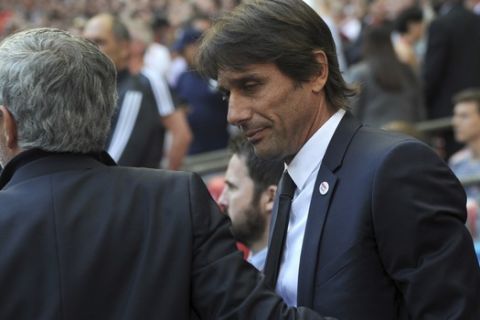 Manchester United manager Jose Mourinho, left, greets Chelsea manager Antonio Conte prior to the English FA Cup final soccer match between Chelsea v Manchester United at Wembley stadium in London, England, Saturday, May 19, 2018. (AP Photo/Rui Vieira)