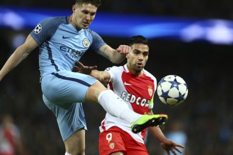 Manchester City's John Stones clears in front of Monaco's Radamel Falcao during the Champions League round of 16 first leg soccer match between Manchester City and Monaco at the Etihad Stadium in Manchester, England, Tuesday Feb. 21, 2017. (AP Photo/Dave Thompson)