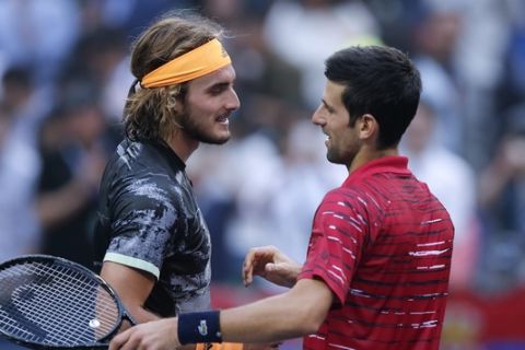 Stefanos Tsitsipas, left, of Greece is congratulated by Novak Djokovic of Serbia after winning in their men's singles quarterfinals match at the Shanghai Masters tennis tournament at Qizhong Forest Sports City Tennis Center in Shanghai, China, Friday, Oct. 11, 2019. (AP Photo/Andy Wong)