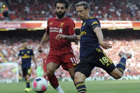 Liverpool's Mohamed Salah, left, challenges Arsenal's Nacho Monreal during the English Premier League soccer match between Liverpool and Arsenal at Anfield stadium in Liverpool, England, Saturday, Aug. 24, 2019. (AP Photo/Rui Vieira)