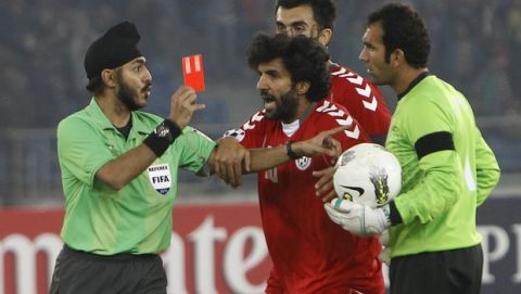 Referee Sukhbir Singh, left, gives a red card to Afghanistan's goalkeeper and captain Hameedullah Yousufzari, right, as teammate Djelaludin Sharityar, center, protests the decision, during the final soccer match against India in the SAFF Championships in New Delhi, India, Sunday, Dec. 11, 2011. India defeated Afghanistan 4-0 to lift the title. (AP Photo/Gurinder Osan)