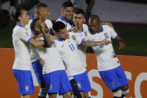 Brazil's Philippe Coutinho, center, celebrates scoring his side's opening goal with teammates during a Copa America Group A soccer match at the Morumbi stadium in Sao Paulo, Brazil, Friday, June 14, 2019. (AP Photo/Nelson Antoine)